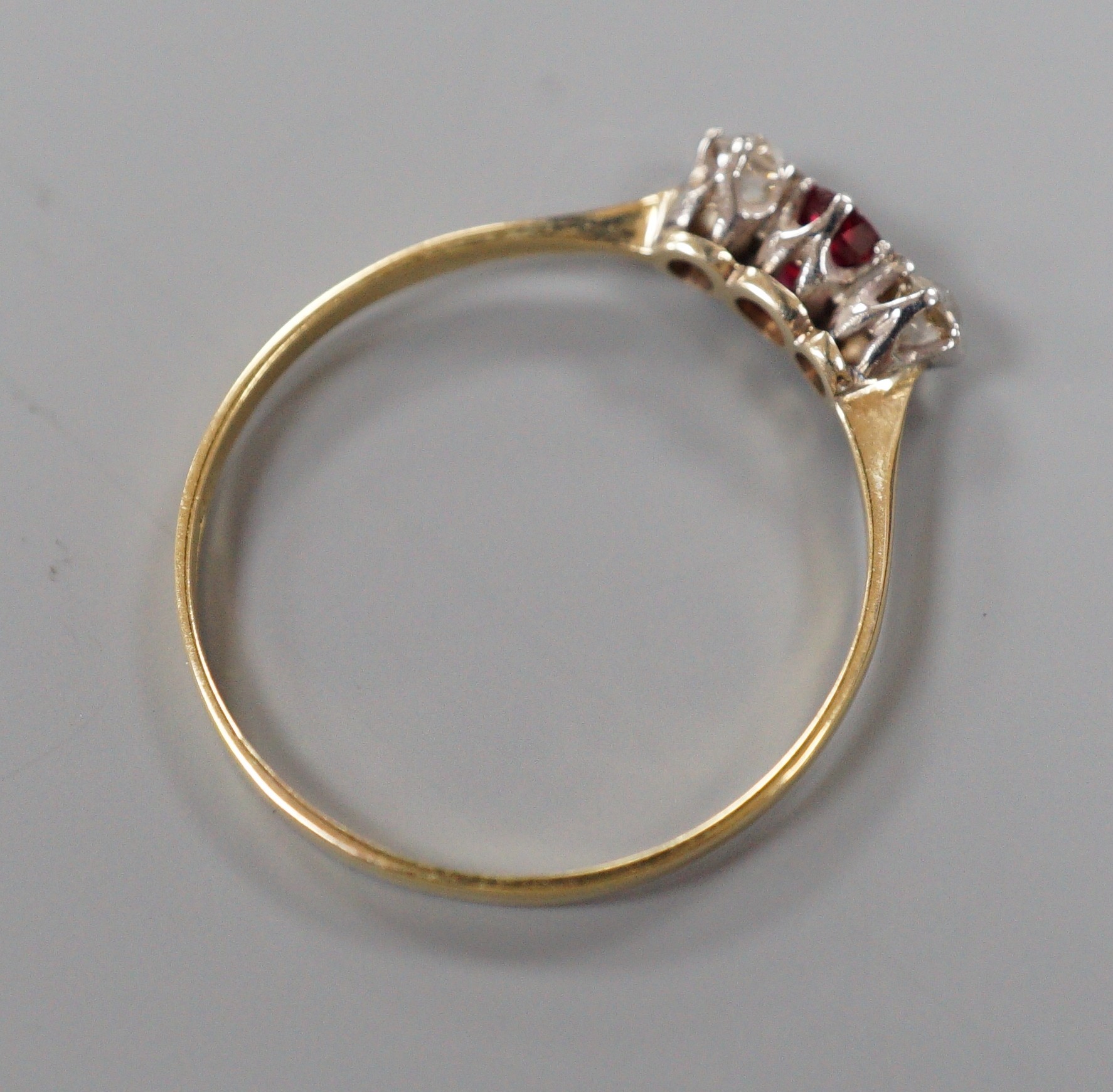 An 18ct, ruby and diamond set three stone ring, size V, gross weight 1.7 grams.